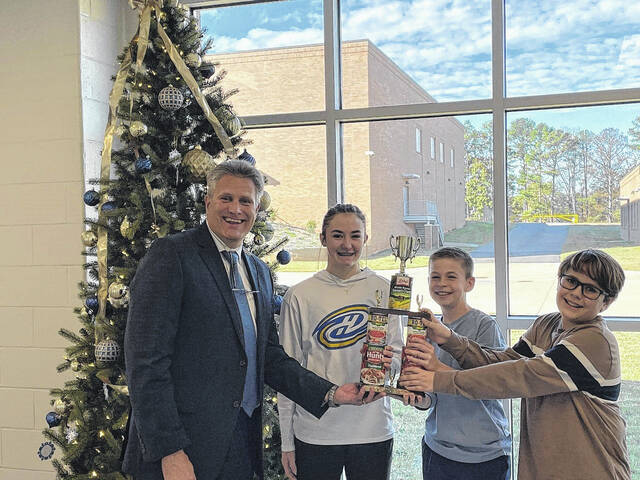 Anderson One Superintendent Robbie Binnicker presents the middle school trophy for the Anderson One Food Fight Against Hunger to Wren Middle students (left to right) Scarlett Howell, Colsen Ellenburg, and Truitt Gambrell.
                                 Courtesy photo