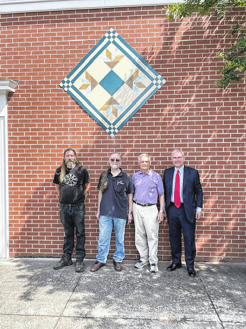 Upstate Heritage Quilt Trail no. 253, Daylilies, has found a new home on Robinsons in Old Market Square, Easley. Installed by Chris Shipman, Jack Parris of Pickens. Quilt owner and sponsor Kent Dykes and business owner of site, Al Robinson.
                                 Courtesy photo