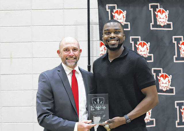 Pictured is Liberty High School Principal John Garrett recently presenting the Hall of Fame plaque to track star Keyshawn King.
                                 Courtesy photo