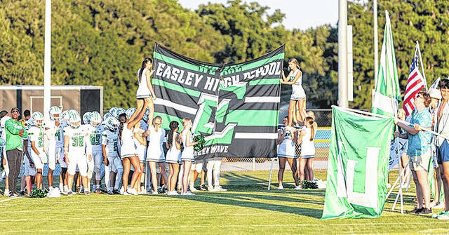 Easley cheerleaders and students help the Green Wave take the field.
Mark Beery | The Easley Progress