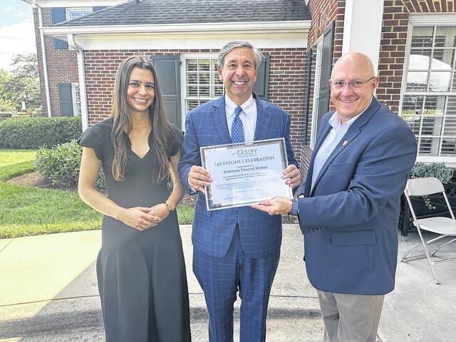 Anna Robinson and her dad, Chris, have continued the family business of Robinson Funeral Home. Brian Swords (right) of the Easley Chamber presented the Robinson family with a plaque for their 150 years of service to the Easley community.
                                 Jeff Holt | The Easley Progress