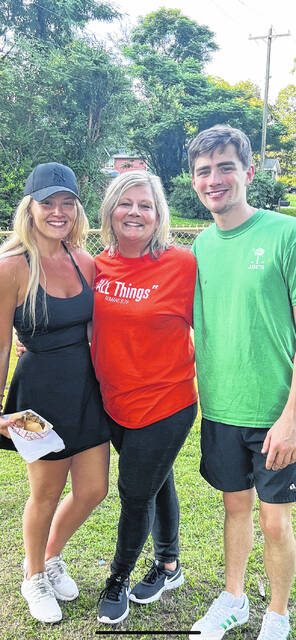 Pictured is Julie (Lesley) Ellison with her two kids (Lesley and Trey) on the night in 2024 that she threw out the first pitch of an Easley American Legion baseball game. Julie said it was a way to honor her dads legacy and his love for American Legion baseball. Julie (1984 EHS grad) and her sister Carol Jo (Lesley) Baumgarner will return as batgirls on May 29 for the Post 52 Legion Baseball Alumni Day.
                                 Photo Submitted